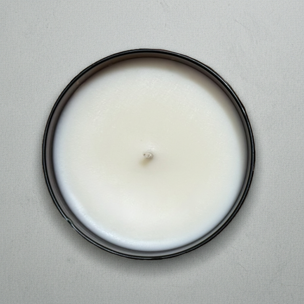 White candle with gray background Birds Eye view with butterscotch sandalwood fragrance