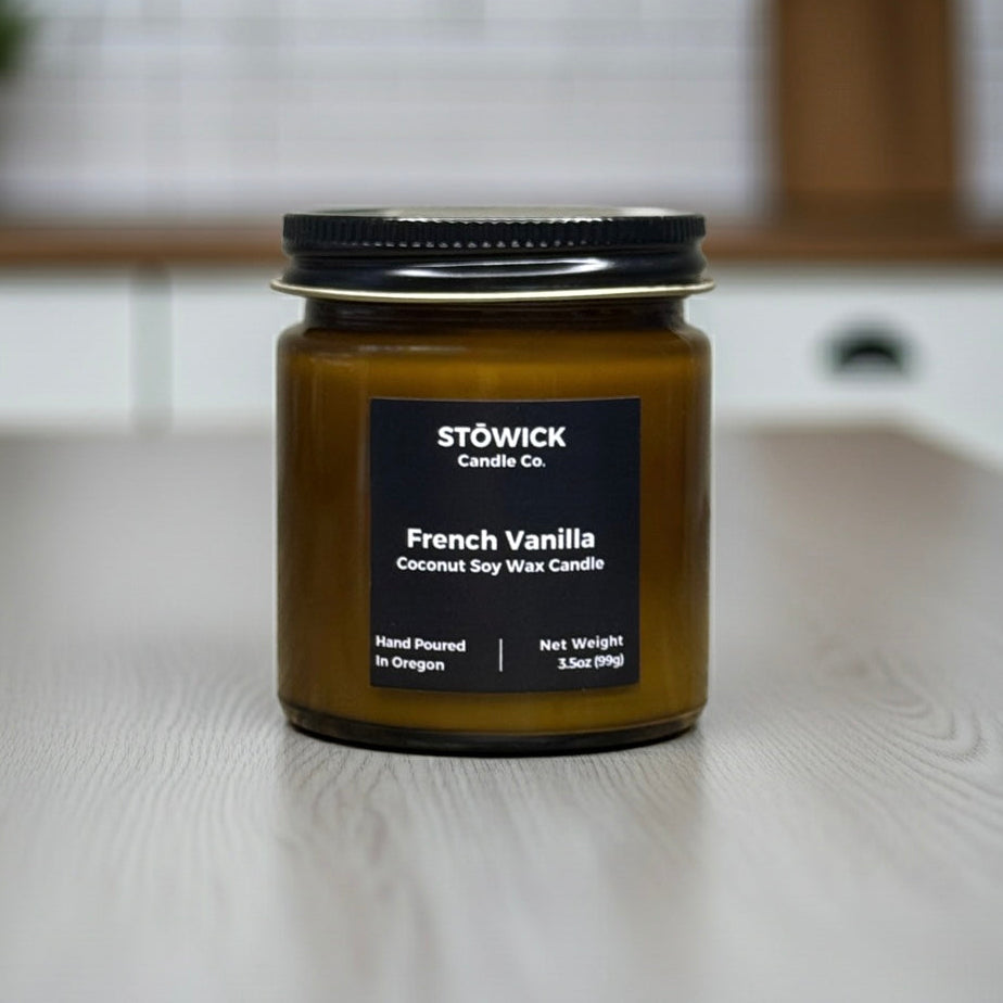 Stowick Candle Co French Vanilla mini candle on a wooden surface with a blurred background