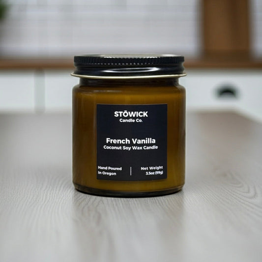 Stowick Candle Co French Vanilla mini candle on a wooden surface with a blurred background