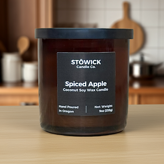Stowick Candle Co. Spiced Apple candle on a wooden surface with a kitchen background