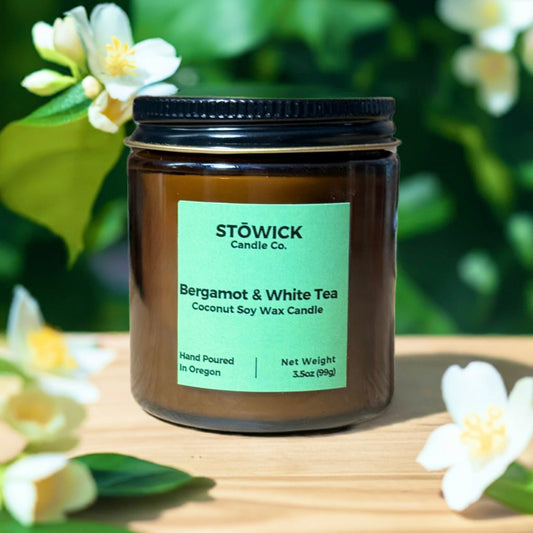 a mini bergamot and white tea mini candle in an amber jar with a green label