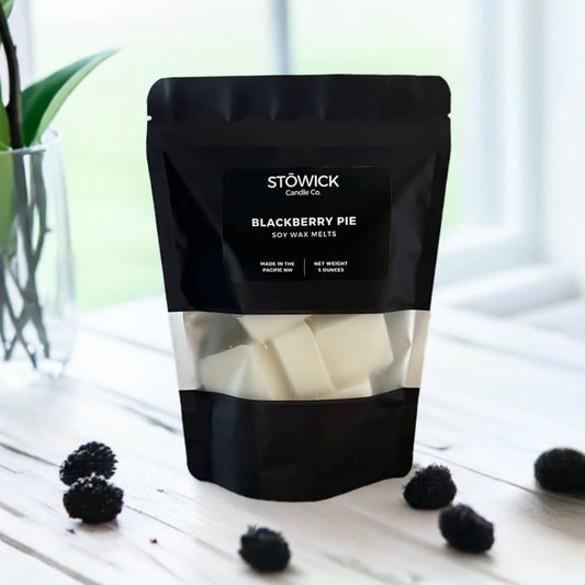 a 5 ounce black bag of pure soy wax melts sitting on a table with blackberry pie scent