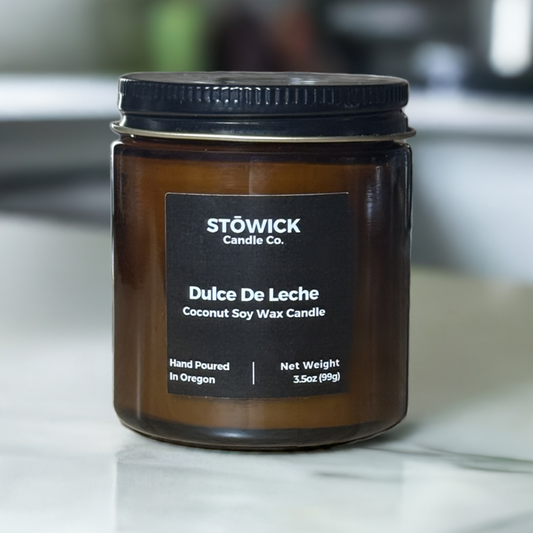 a mini candle that is 3.5oz in a amber jar with a black label in dulce de leche fragrance