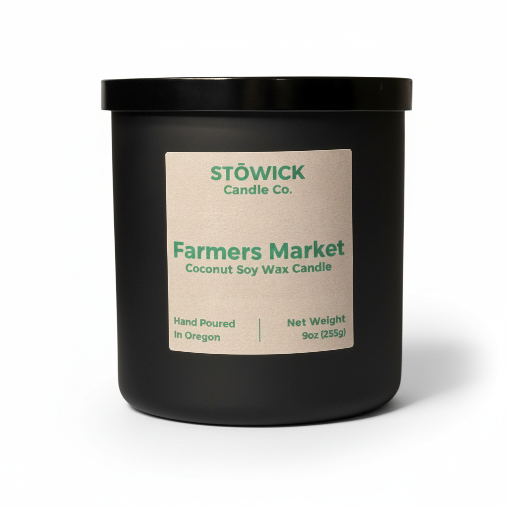 A farmers market fragranced tumbler candle in a black jar with a brown label and white background