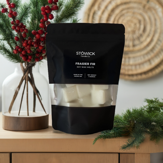 a bag of pure soy wax frasier fir wax melts sitting on a table next to pine needles