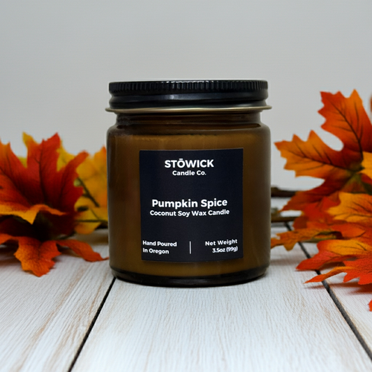 Stöwick Candle Co. Pumpkin Spice mini candle on a wooden surface with autumn leaves.