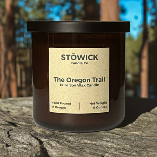the Oregon trail tumbler candle sitting outside on a rock