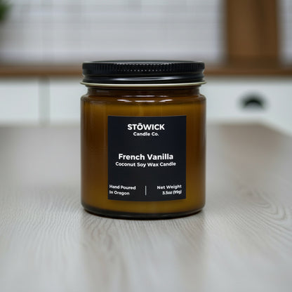 Stowick Candle Co French Vanilla mini candle on a wooden surface with a blurred background