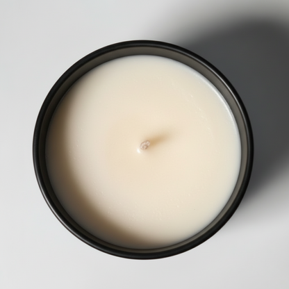 A Birds Eye view of a lemon zest scented tumbler candle in a black jar 