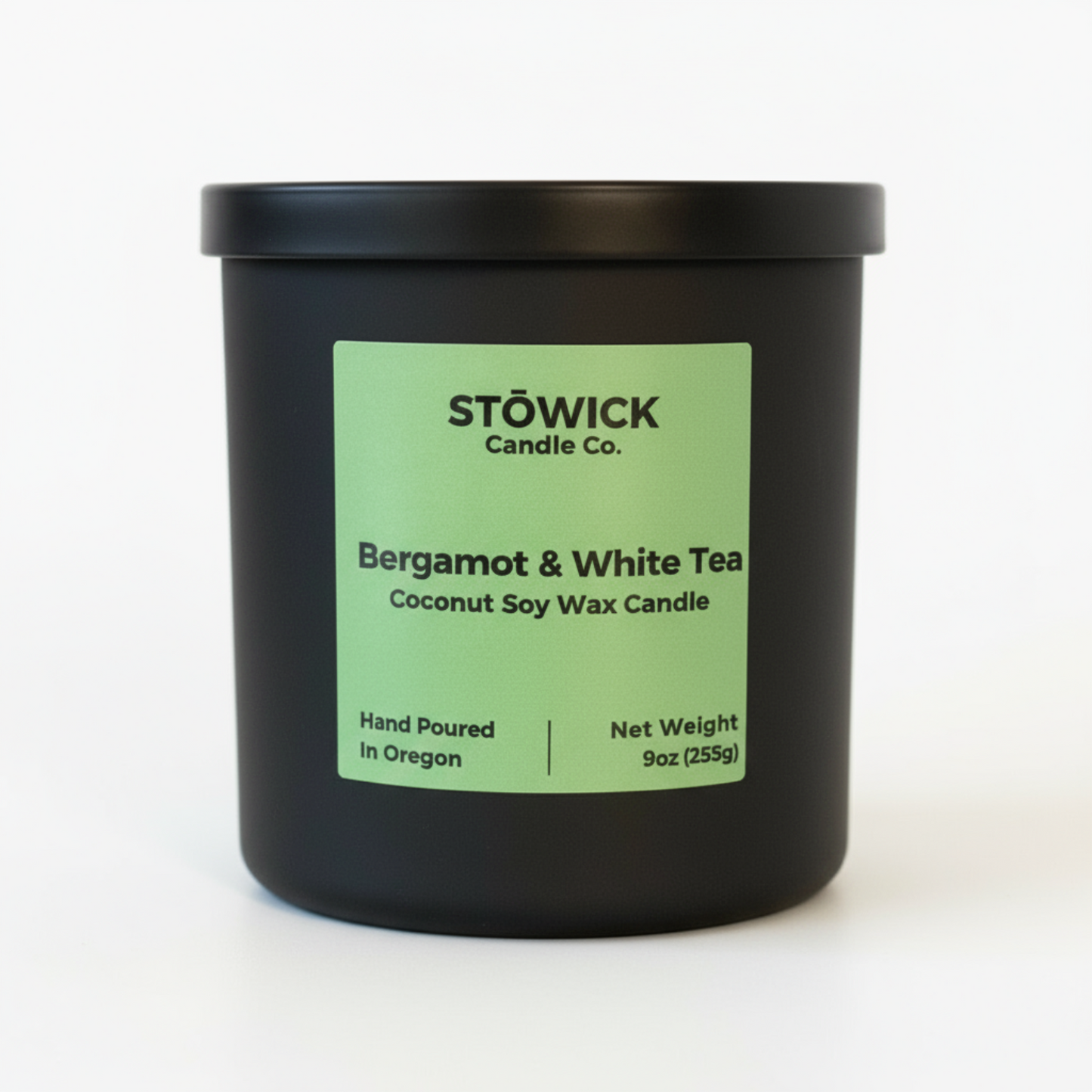 Black candle jar with a green label featuring Stowick Candle Co. on a white background with the fragrance bergamot and white tea 