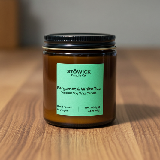 A bergamot and white tea mini candle in an amber jar with a green label