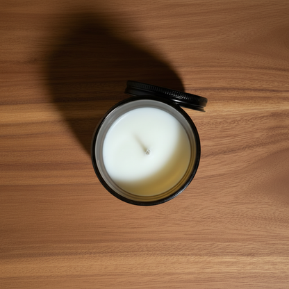 A Birds Eye view of a butterscotch sandalwood mini candle with white wax on a sandalwood table 
