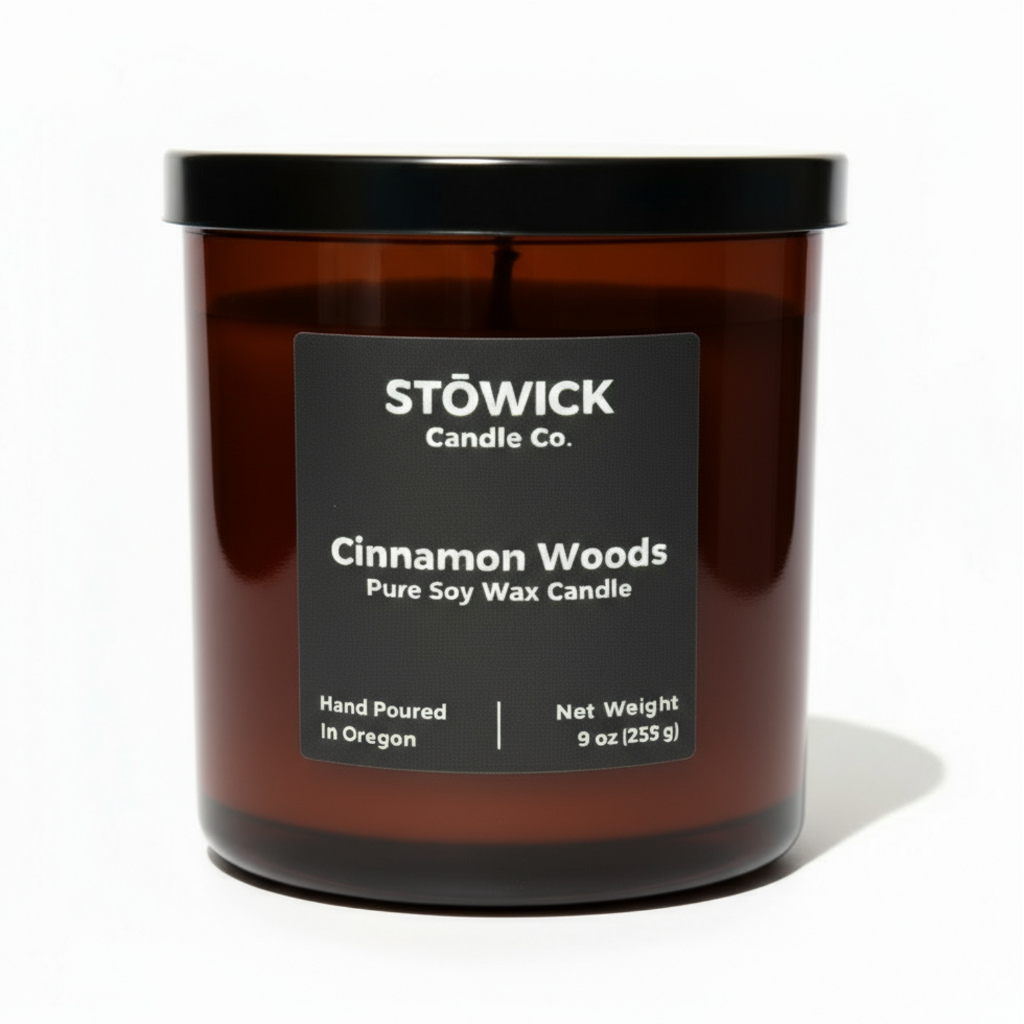 Stowick Candle Co. cinnamon woods candle with a black label on a white background
