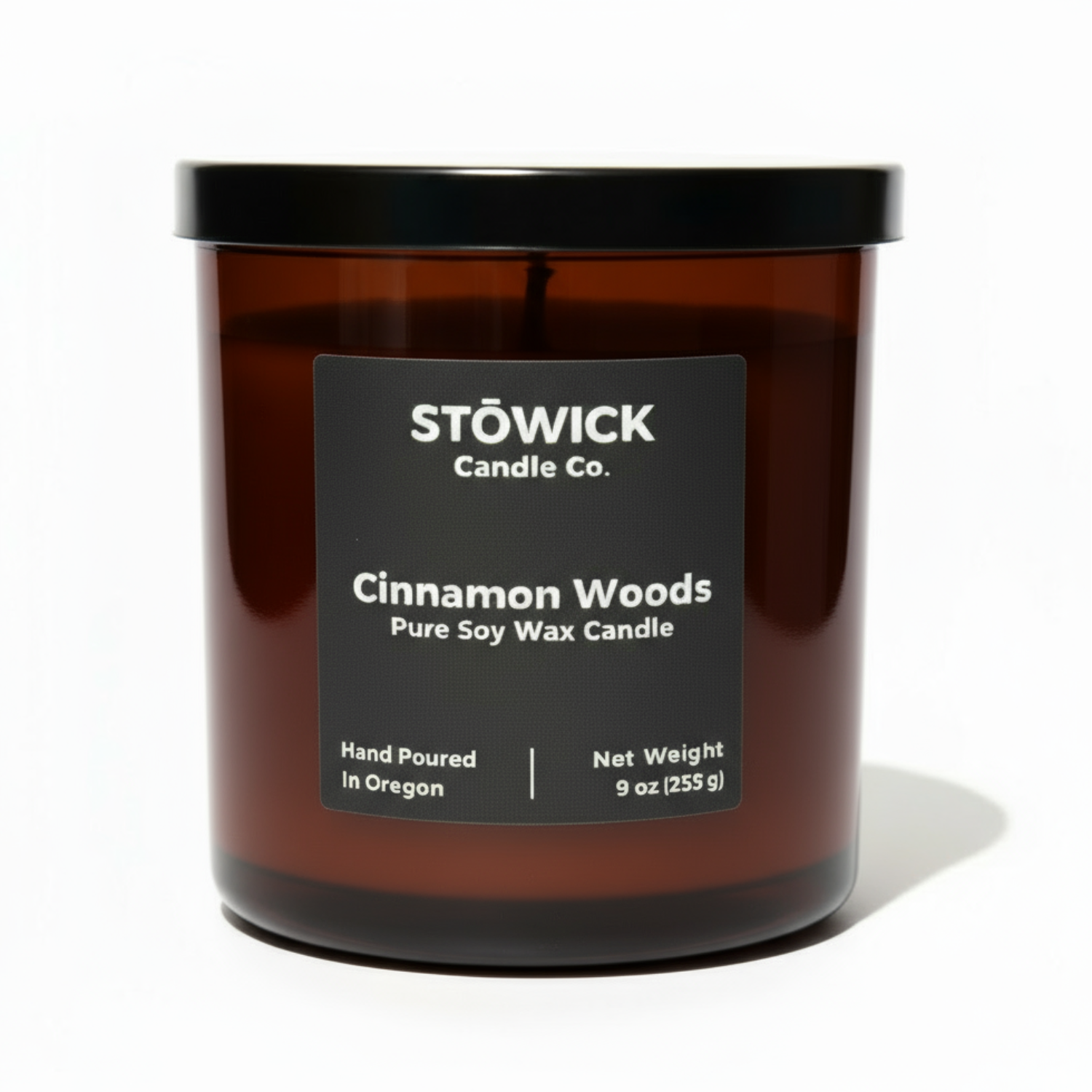 Stowick Candle Co. cinnamon woods candle with a black label on a white background