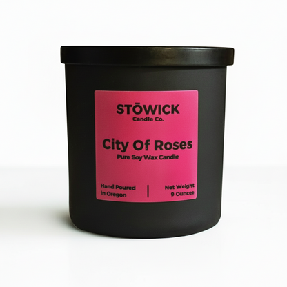 A city of roses scented tumbler candle in a black jar with a white background 