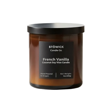 A French vanilla tumbler candle in and amber jar with a black label against a white background 