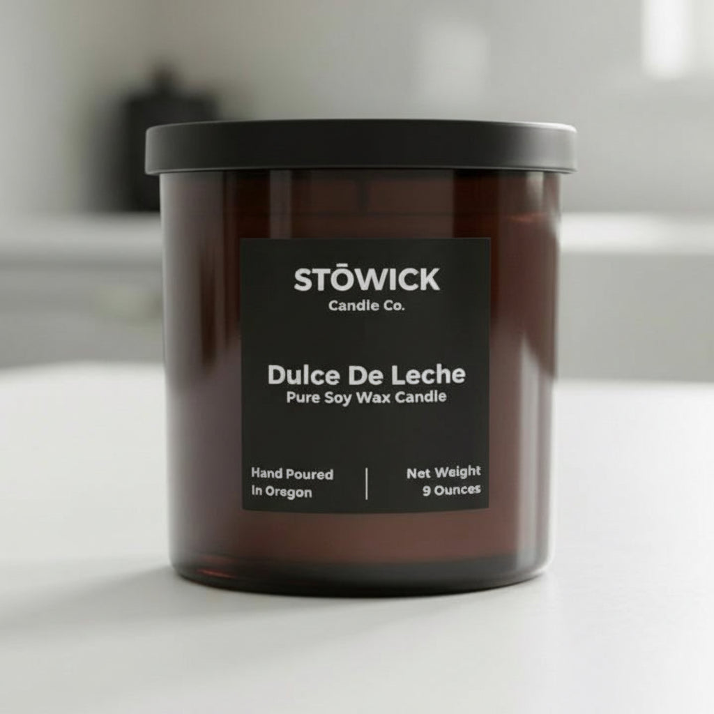 Stowick Candle Co. Dulce De Leche candle in a brown jar on a white surface.