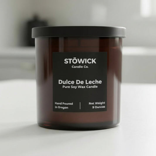 Stowick Candle Co. Dulce De Leche candle in a brown jar on a white surface.