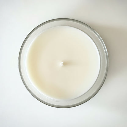 A Birds Eye view of a grapefruit scented candle with a white background