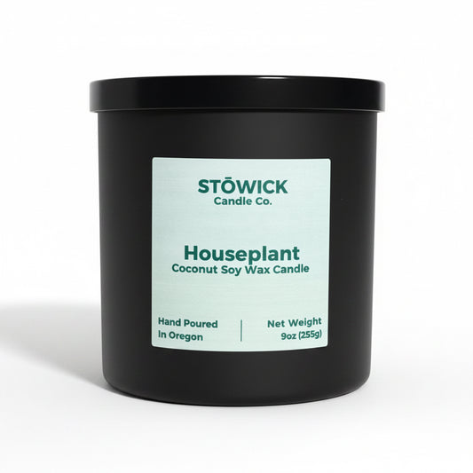 A houseplant scented tumbler candle in a jack jar with a black lid on a white background