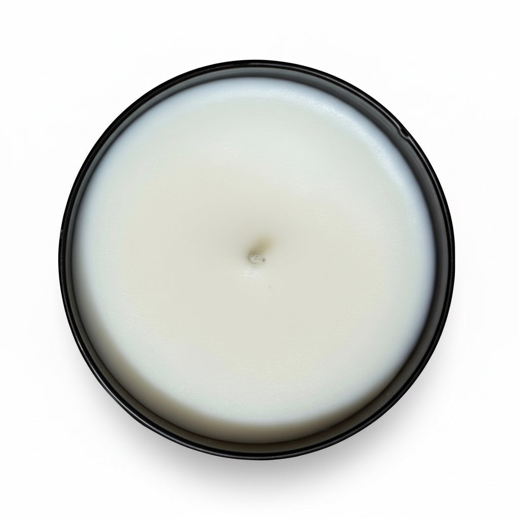 A Birds Eye view of the mt hood tumbler candle in a black jar against a white background