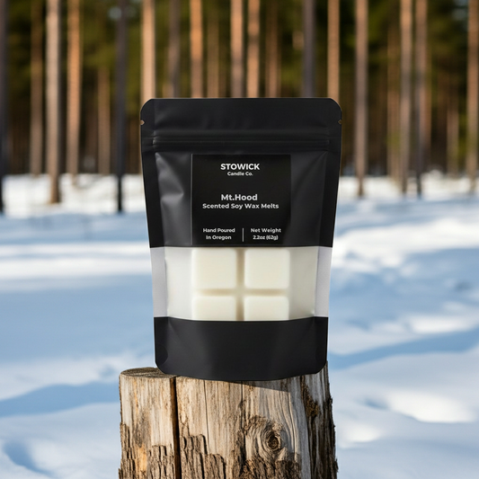 Stowick mt hood scented wax melts package on a wooden stump with a snowy forest background