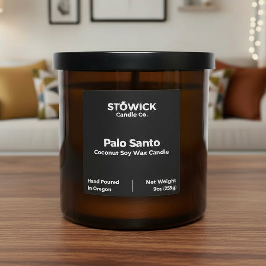 Stowick Palo Santo tumbler candle on a wooden surface with a living room background