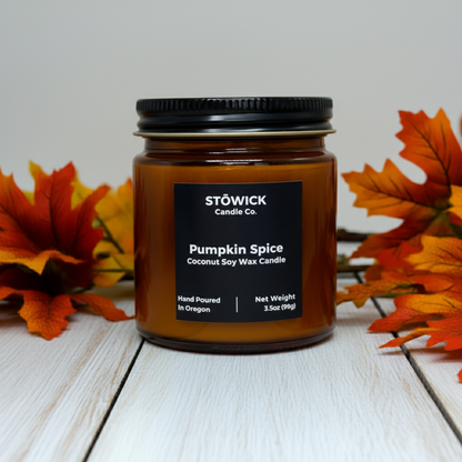 Stöwick Candle Co. Pumpkin Spice mini candle on a wooden surface with autumn leaves.