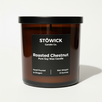 A roasted chestnut candle in an amber glass jar made by Stowick candles with a black label