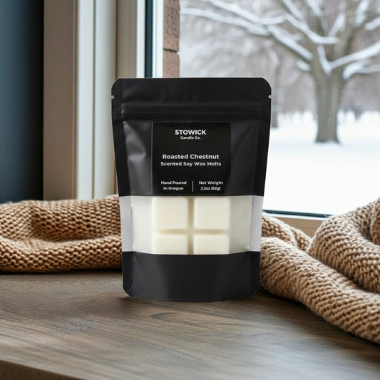 Stowick roasted chestnut scented soy wax melts packaging on a wooden surface with a window in the background.