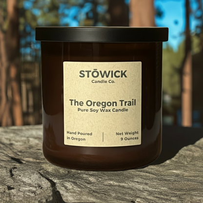 the Oregon trail tumbler candle sitting outside on a rock